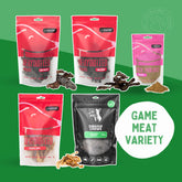 A variety of packaged dog treats, including Emu Strips, Goat Medley, Kangaroo Heart, Crocodile Jerky, and Kangaroo Meal Enricher, arranged on a green background with a 'GAME MEAT VARIETY' label.